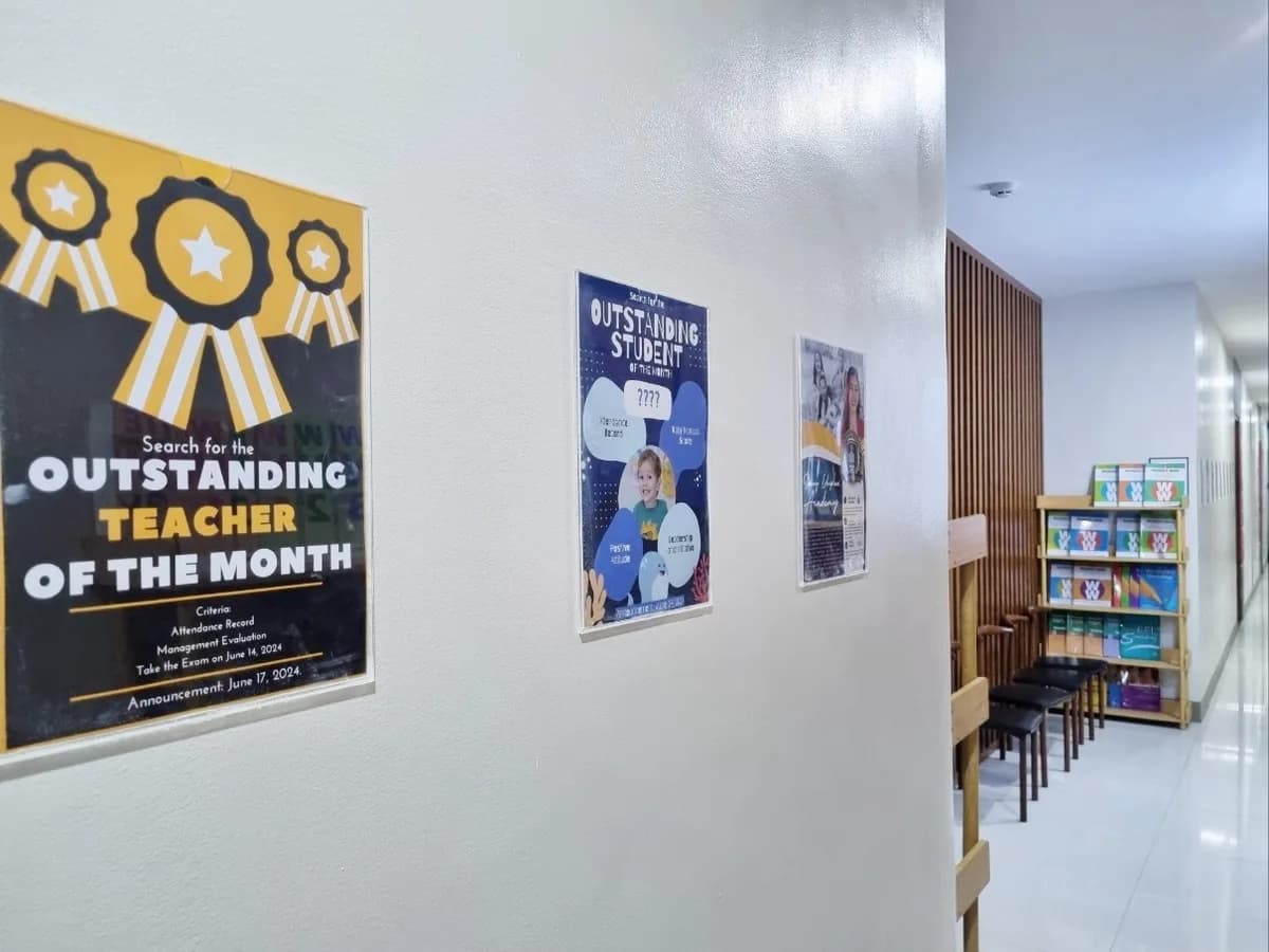 SWING EDUPLEX ACADEMY 복도의 학습 게시판과 영어 교재 서가